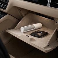 A beige car glove compartment organizer tray holding a white pet fur remover and a black pet fur remover, set inside a vehicle interior.